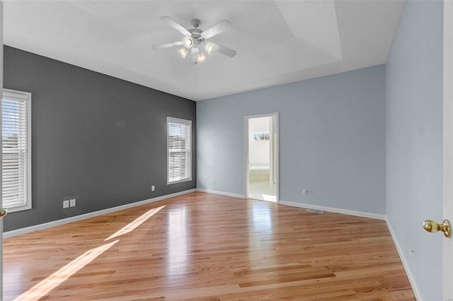 empty room with ceiling fan and light hardwood / wood-style flooring