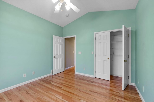 unfurnished bedroom featuring ceiling fan, lofted ceiling, light wood-type flooring, and a closet