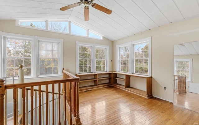 unfurnished sunroom with lofted ceiling with beams, a healthy amount of sunlight, and ceiling fan