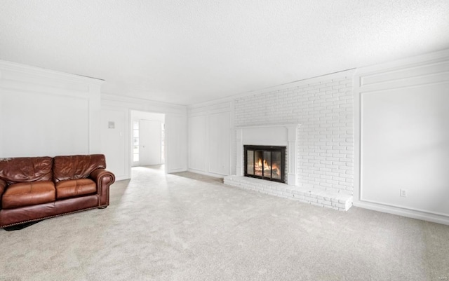 carpeted living room featuring a brick fireplace, brick wall, and a textured ceiling