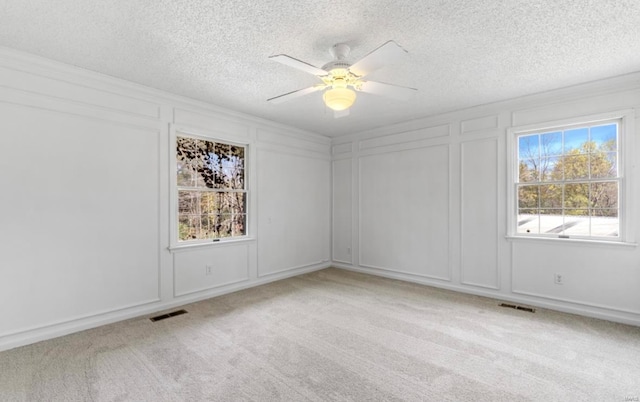 carpeted empty room featuring a textured ceiling and ceiling fan