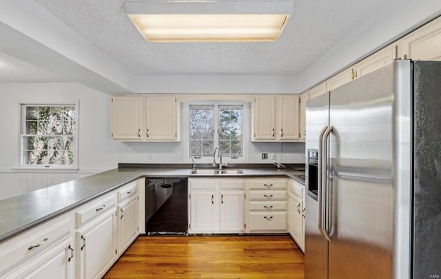 kitchen with dishwasher, a wealth of natural light, sink, and stainless steel fridge with ice dispenser