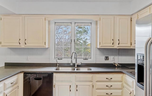 kitchen with black dishwasher, cream cabinets, sink, and stainless steel fridge