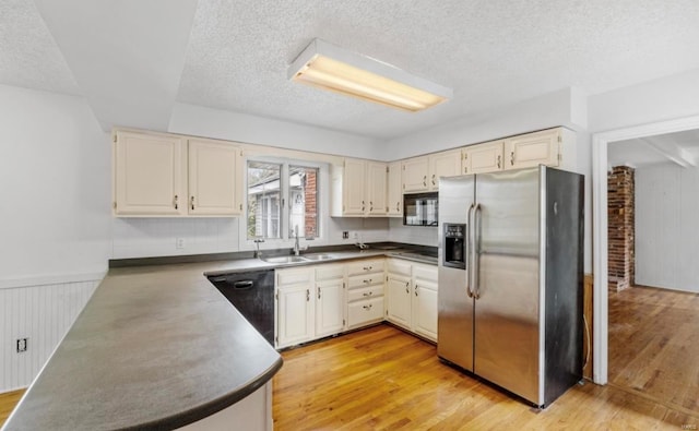 kitchen featuring black appliances, a textured ceiling, sink, and light hardwood / wood-style flooring