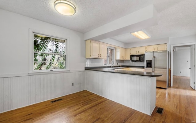 kitchen featuring kitchen peninsula, light hardwood / wood-style flooring, a textured ceiling, and stainless steel fridge with ice dispenser