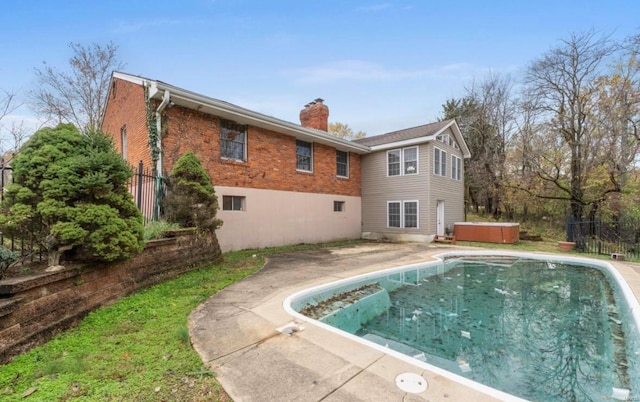 back of property featuring a patio and a hot tub