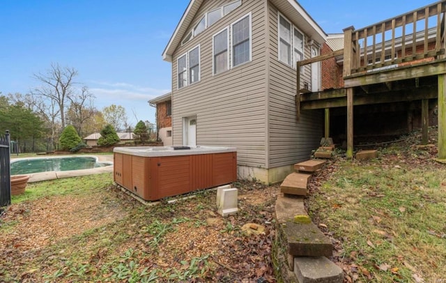 rear view of house featuring a swimming pool with hot tub