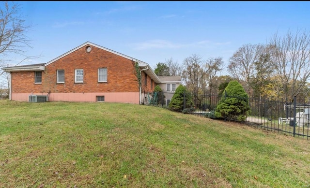 view of side of home featuring central AC and a yard