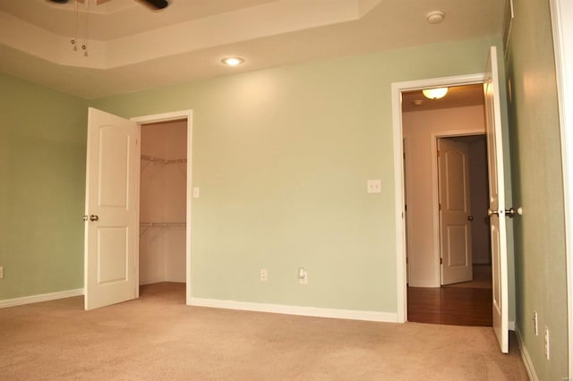 empty room featuring light colored carpet and a tray ceiling