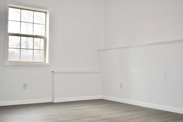 unfurnished room featuring plenty of natural light and wood-type flooring