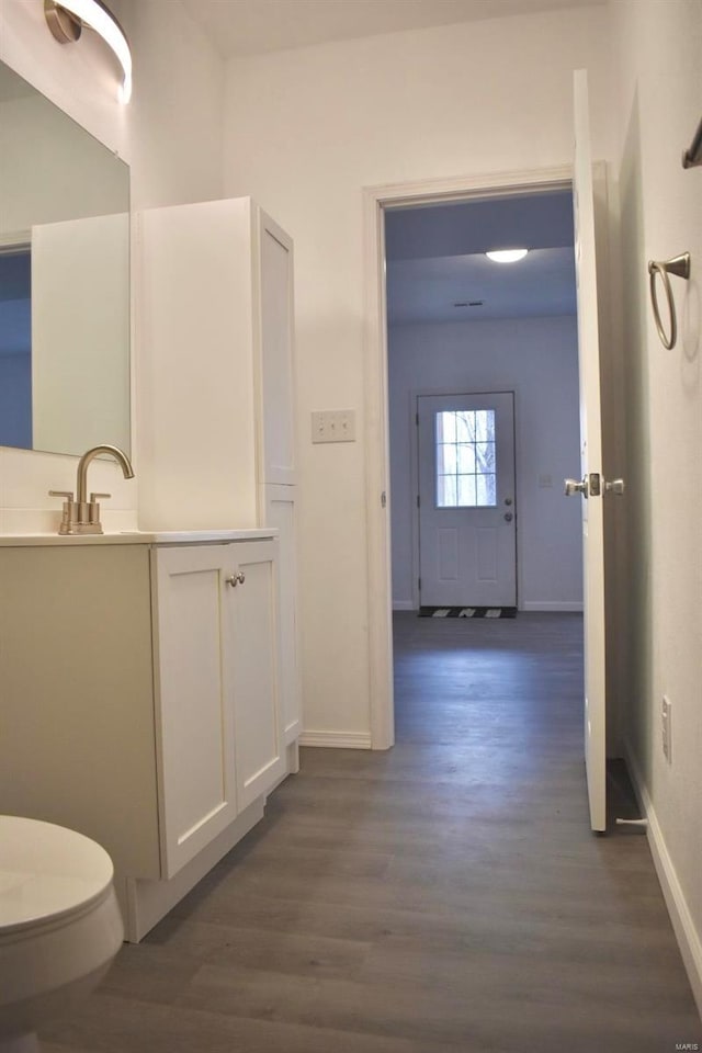 bathroom with hardwood / wood-style flooring, vanity, and toilet