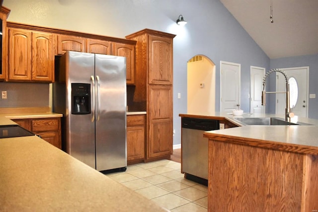 kitchen with sink, light tile patterned floors, stainless steel appliances, and high vaulted ceiling