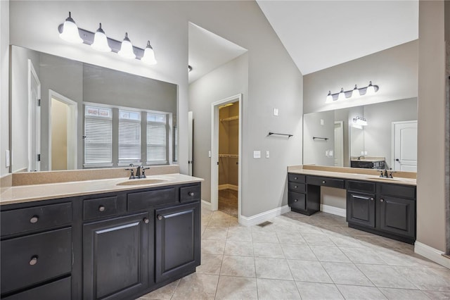 bathroom featuring tile patterned floors, vanity, and lofted ceiling