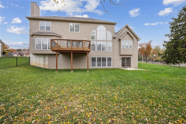 back of property with french doors, a deck, and a lawn