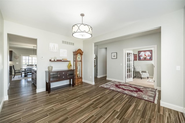 foyer featuring wood finish floors, visible vents, and baseboards