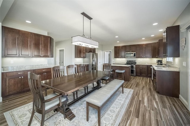 dining room with baseboards, wood finished floors, and recessed lighting