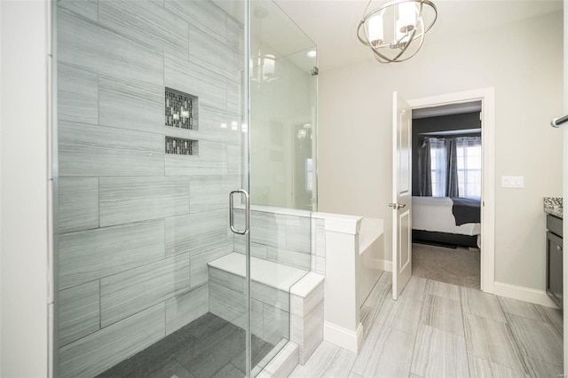 ensuite bathroom featuring ensuite bathroom, a shower stall, vanity, and baseboards