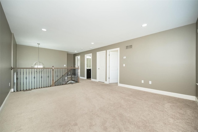 carpeted empty room featuring recessed lighting, visible vents, and baseboards