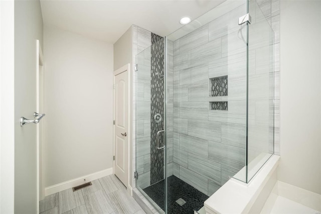 full bath featuring a stall shower, visible vents, and baseboards