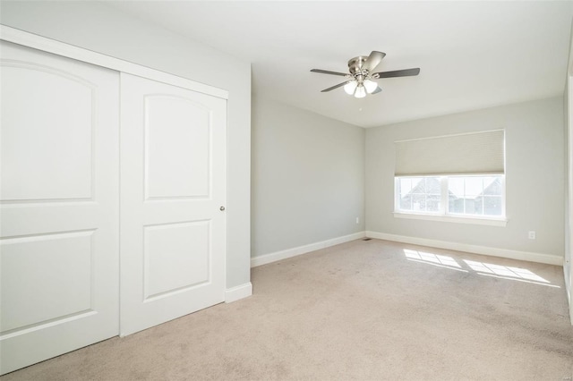 unfurnished bedroom featuring ceiling fan, a closet, carpet flooring, and baseboards