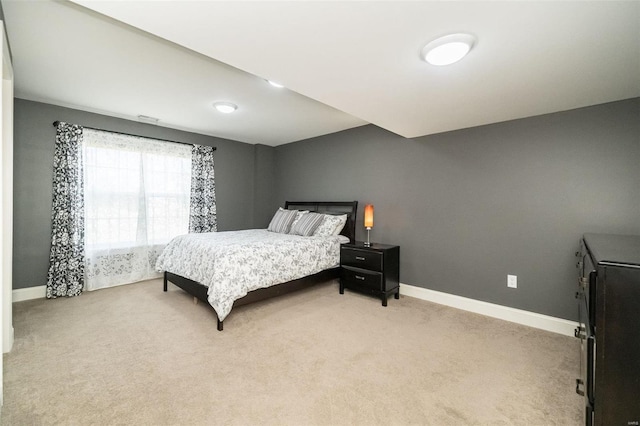 bedroom featuring light carpet and baseboards