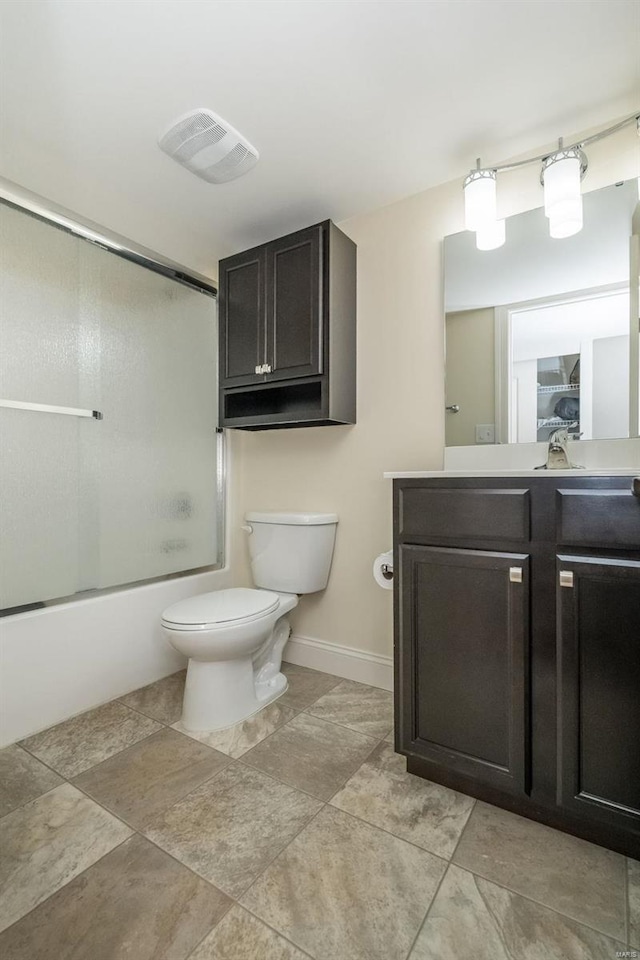 full bath featuring toilet, vanity, visible vents, baseboards, and combined bath / shower with glass door