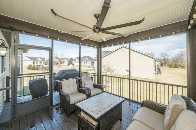 sunroom with a residential view and ceiling fan