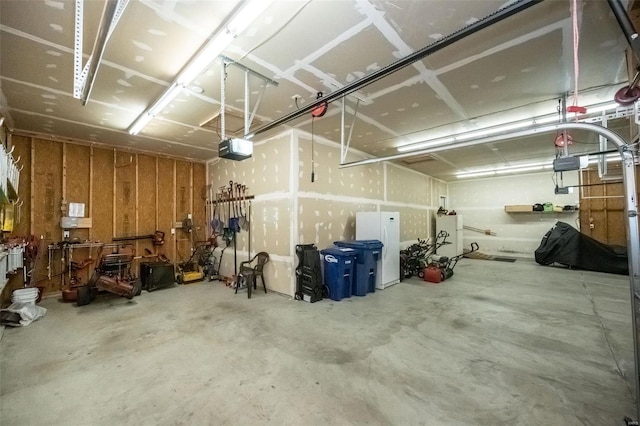 garage with a garage door opener and freestanding refrigerator