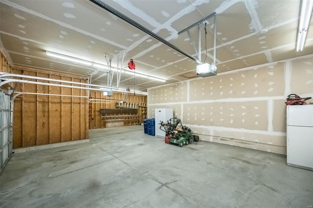 garage with a garage door opener and freestanding refrigerator