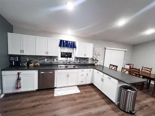 kitchen with white cabinetry, sink, stainless steel dishwasher, dark hardwood / wood-style floors, and backsplash