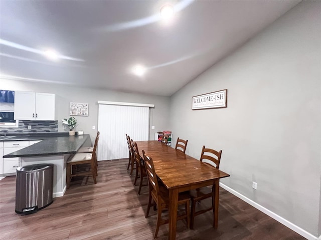 dining area with dark hardwood / wood-style flooring and lofted ceiling