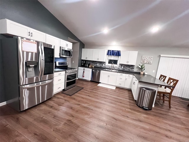 kitchen with white cabinetry, hardwood / wood-style flooring, and appliances with stainless steel finishes