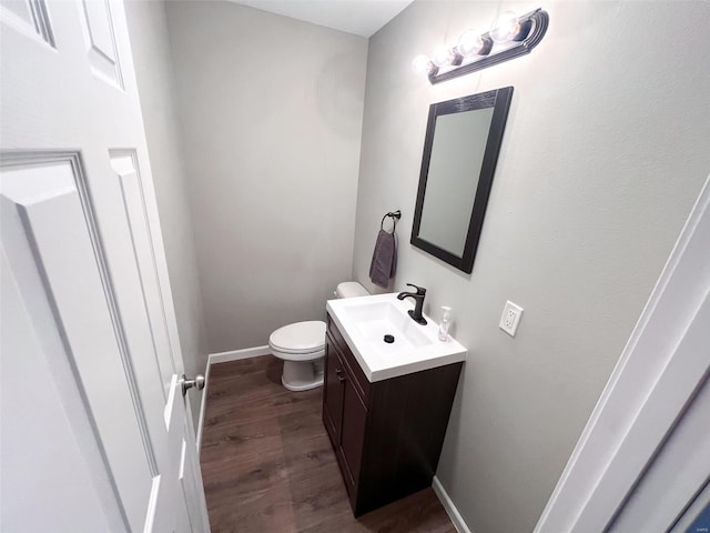 bathroom featuring hardwood / wood-style floors, vanity, and toilet