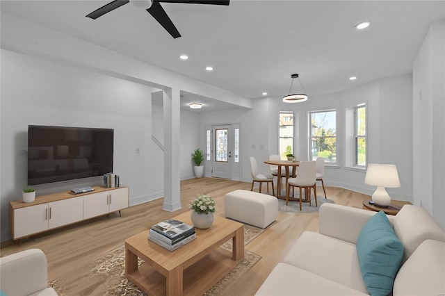 living room featuring light hardwood / wood-style floors and ceiling fan