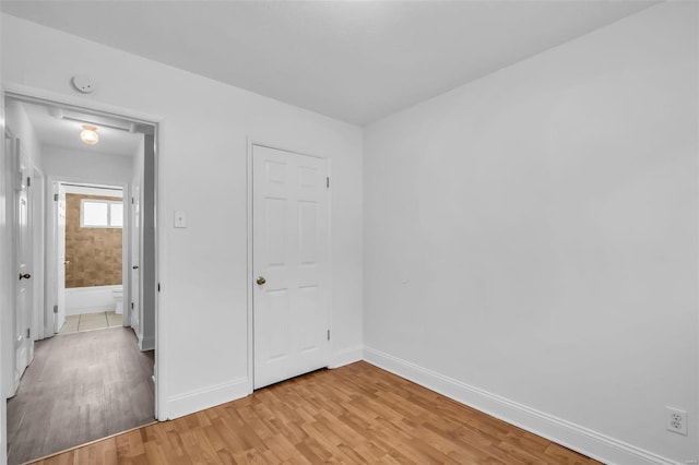 unfurnished bedroom featuring a closet and light wood-type flooring