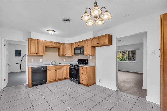 kitchen featuring black appliances, sink, tasteful backsplash, decorative light fixtures, and light hardwood / wood-style floors