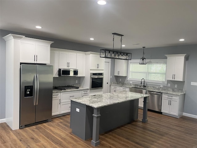 kitchen with stainless steel appliances, white cabinetry, and a center island