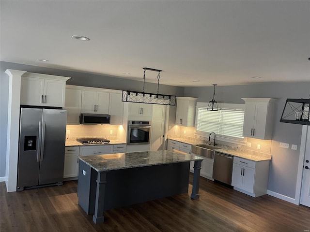 kitchen featuring hanging light fixtures, dark hardwood / wood-style flooring, appliances with stainless steel finishes, and a center island