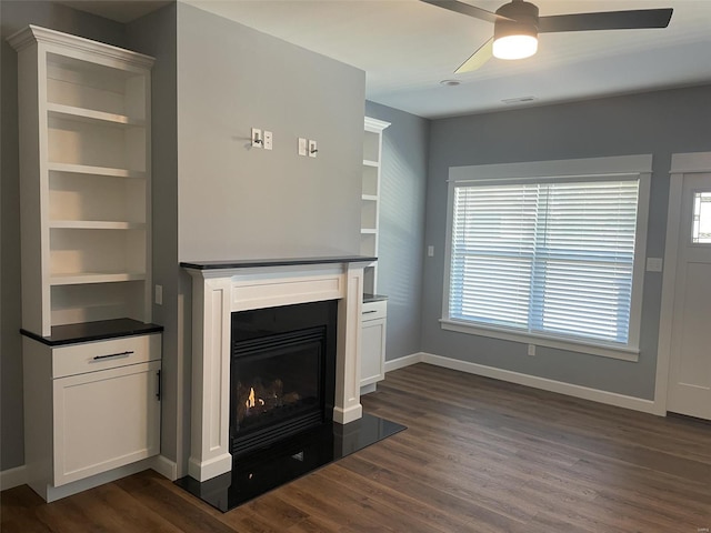 unfurnished living room with ceiling fan and dark hardwood / wood-style floors