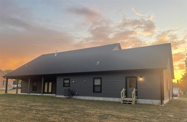 back house at dusk featuring a yard