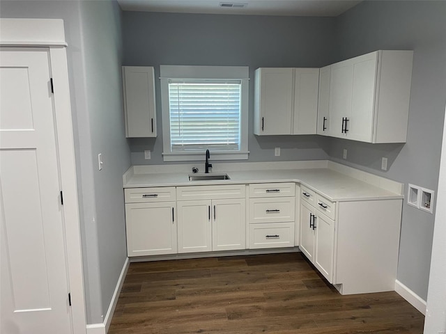 kitchen featuring dark hardwood / wood-style flooring, sink, and white cabinets