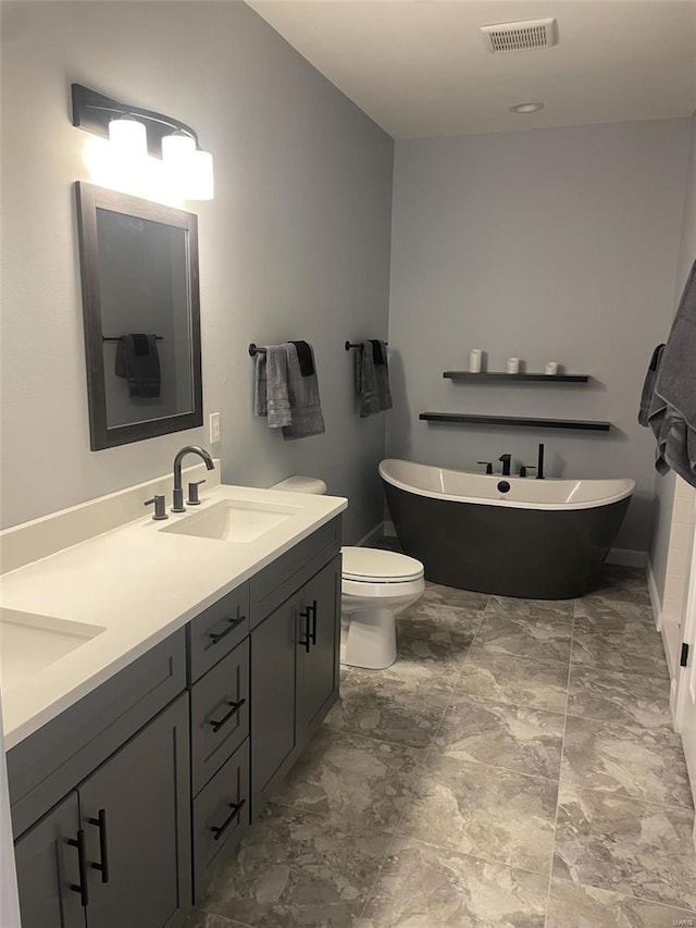 bathroom featuring a tub, vanity, and toilet