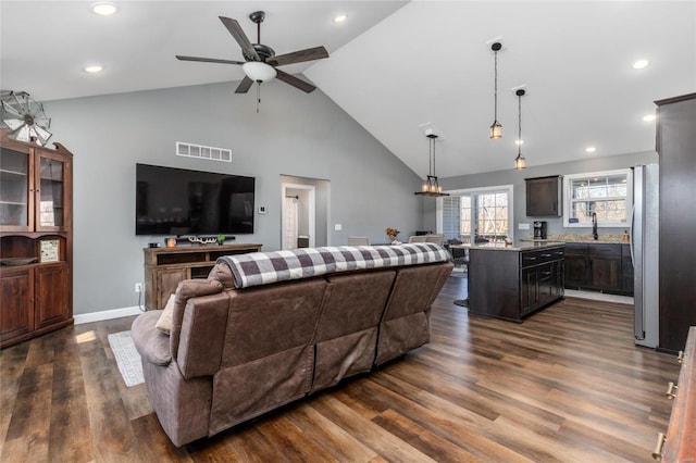 living room with dark hardwood / wood-style flooring, high vaulted ceiling, sink, and ceiling fan