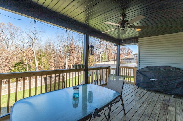 wooden terrace with ceiling fan and area for grilling