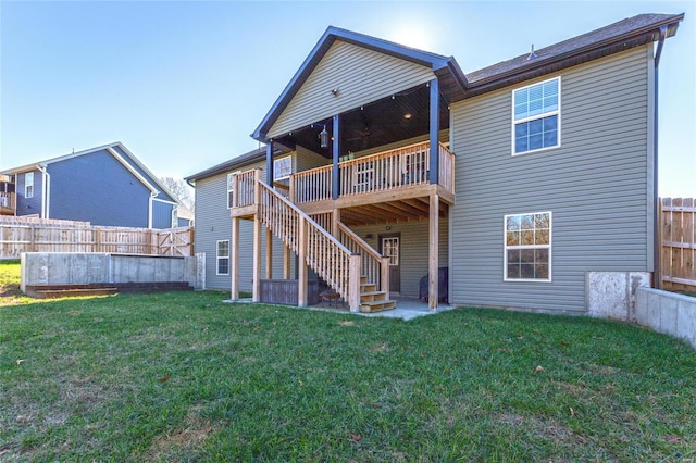 rear view of house featuring a lawn, a balcony, and a patio area