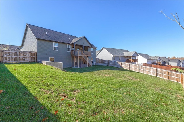 rear view of property with a yard and a wooden deck