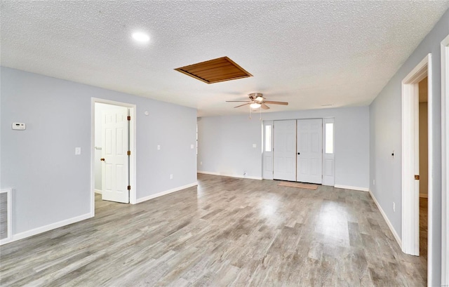 spare room featuring a textured ceiling, light wood-type flooring, and ceiling fan