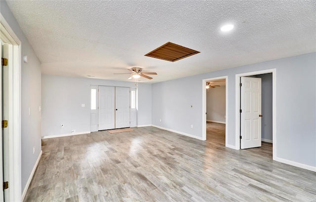 unfurnished room featuring light wood-type flooring and a textured ceiling