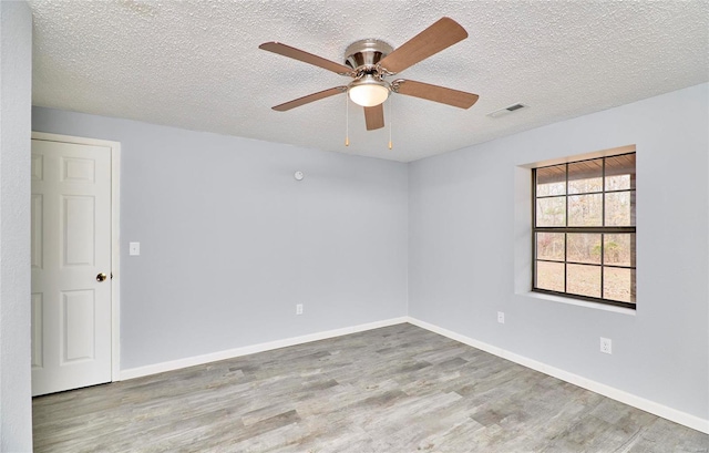 empty room featuring a textured ceiling, light hardwood / wood-style floors, and ceiling fan