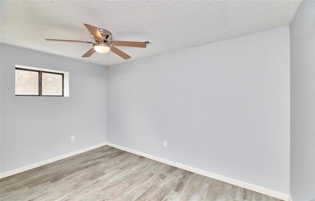 spare room featuring a textured ceiling and light wood-type flooring